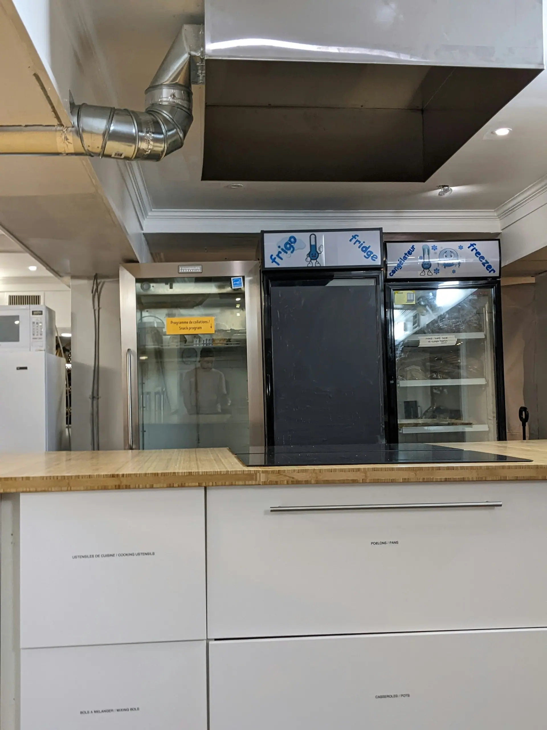 Commercial kitchen with stainless-steel refrigeration and an extraction hood