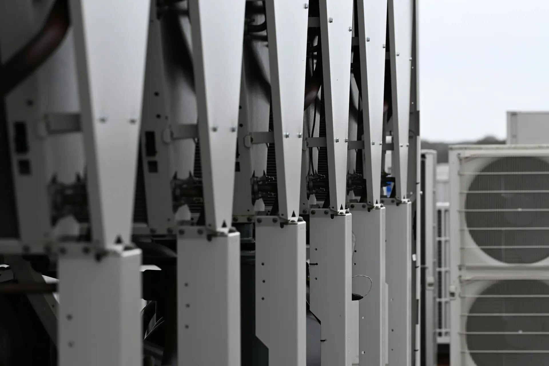 Row of condensing units on steel frames on a commercial rooftop